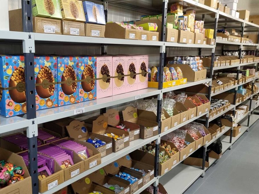 Regale mit verschiedenen Schokoladen in bunten Verpackungen und Pappkartons.